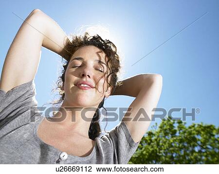 Stock Image - Woman enjoying the sun. Fotosearch