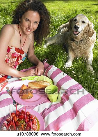 Stock Photo - Woman having a picnic in the garden. Fotosearch