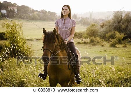 Stock Image - Woman riding horse.. Fotosearch