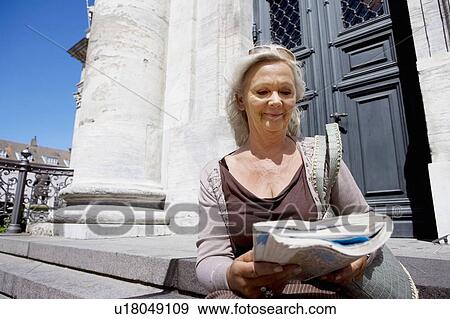 Stock Photo - Woman sitting with map. Fotosearch