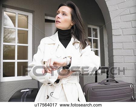 Stock Photo - Woman with suitcases, waiting. Fotosearch