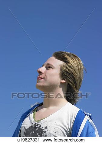 Young man outdoors looking out at something. View Large Photo Image Stock Image - Young man outdoors looking out at something.. Fotosearch