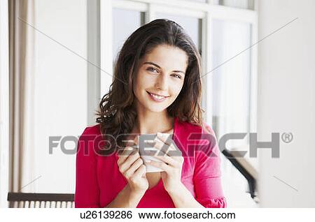 Stock Photograph - Contented woman holds mug. Fotosearch