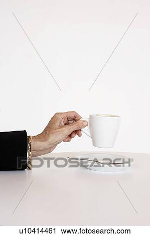 Older woman's hand holding cup of expresso. View Large Photo Image Stock Image - Older woman's hand holding cup of expresso.. Fotosearch
