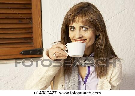 Woman drinking from cup, smiling, portrait View Large Photo Image Stock Photo - Woman drinking from cup, smiling, portrait. Fotosearch