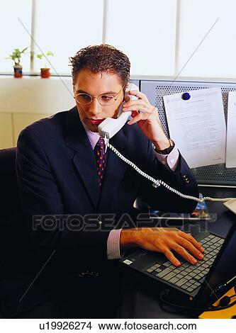 Picture - Talking, Landline Phone, Efficiency, Eyeglasses, Looking Down. Fotosearch