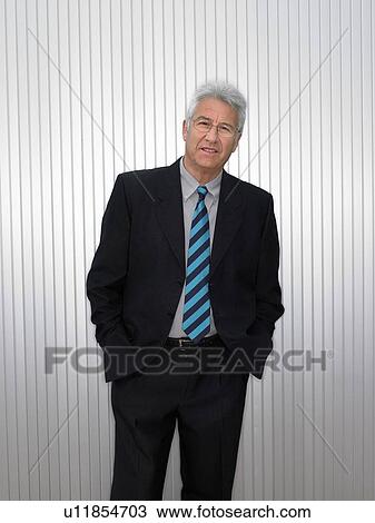 Stock Image - Businessman by a silver wall.. Fotosearch