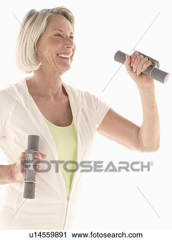Stock Image - Mature woman with hand weights. Fotosearch