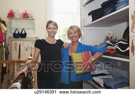 Stock Image - Mother and daughter buying clothes. Fotosearch