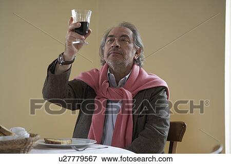 Senior man looking at wine at table View Large Photo Image Stock Photo - Senior man looking at wine at table. Fotosearch