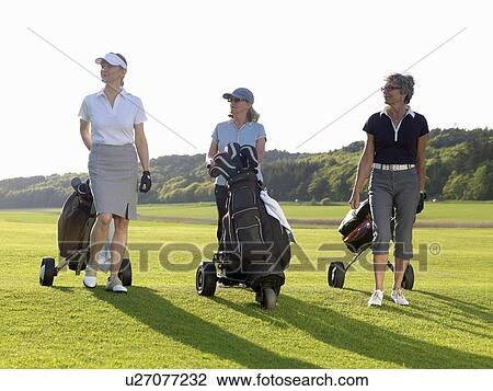 Stock Image - Three women on fairway. Fotosearch
