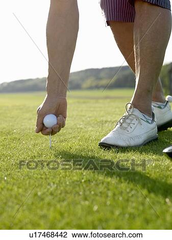 Stock Image - Woman on golf tee. Fotosearch