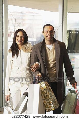 Couple returning from shopping spree View Large Photo Image Stock Photo - Couple returning from shopping spree. Fotosearch