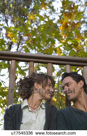 Stock Photograph - Couple sitting on deck.. Fotosearch