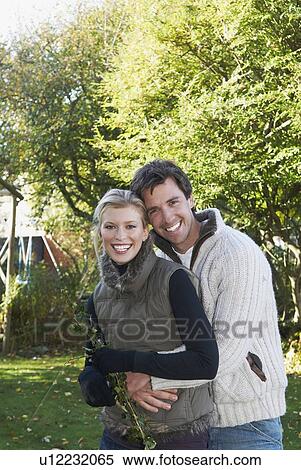 Stock Photography - Happy couple embrace in garden. Fotosearch