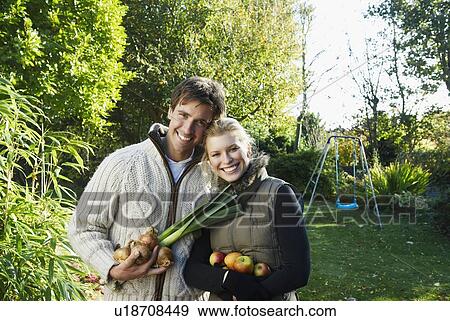 Stock Photo - Happy couple holding vegetables. Fotosearch