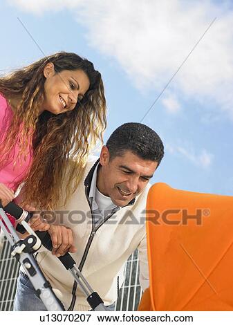 Low angle close up of couple looking into pram, Alicante, Spain, View Large Photo Image Stock Photo - Low angle close up of couple looking into pram, Alicante, Spain,. Fotosearch