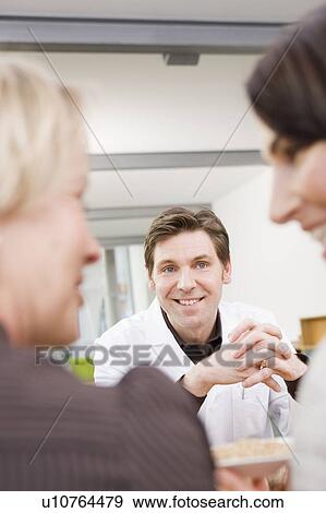 Stock Photo - Man in lab coat in front of two women. Fotosearch