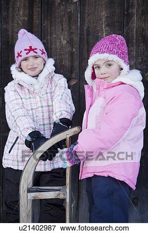 Portrait of young girls with sledge View Large Photo Image Stock Photo - Portrait of young girls with sledge. Fotosearch