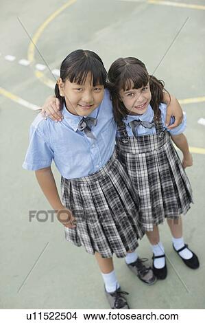 Picture - School girls hugging each other. Fotosearch