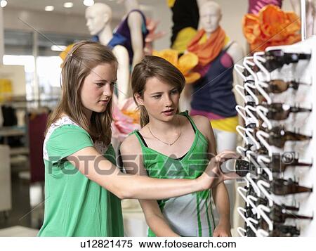 Stock Photography - Two girls shopping sun glasses. Fotosearch