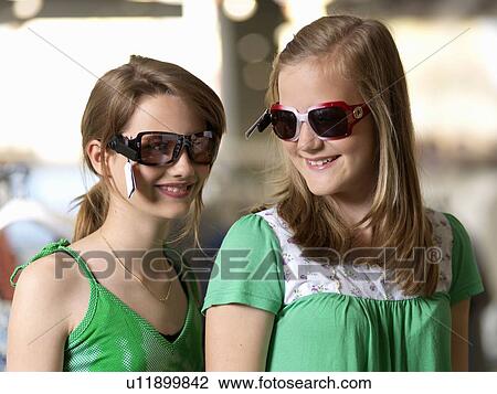 Two girls trying sun glasses View Large Photo Image Stock Image - Two girls trying sun glasses. Fotosearch