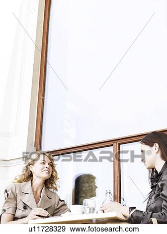 Stock Photo - Two woman at an outdoor restaurant. Fotosearch