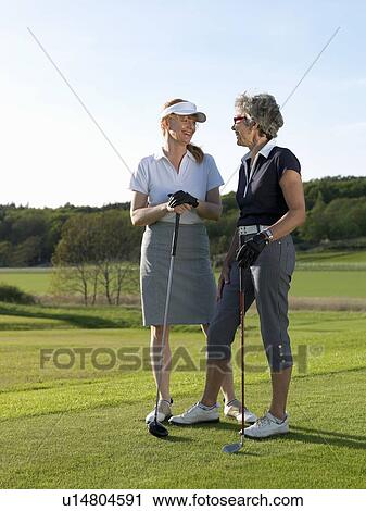 Two women at tee View Large Photo Image Stock Image - Two women at tee. Fotosearch