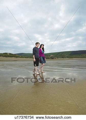 Picture - Young couple walking on beach. Fotosearch