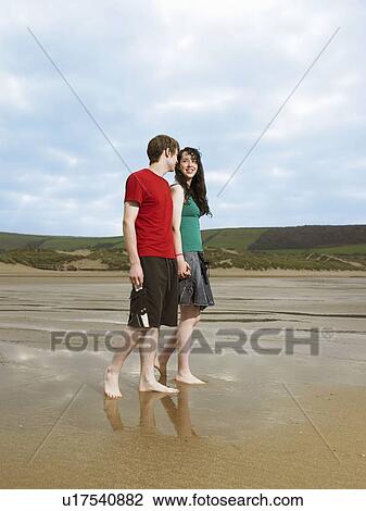 Young couple walking on beach View Large Photo Image Stock Image - Young couple walking on beach. Fotosearch