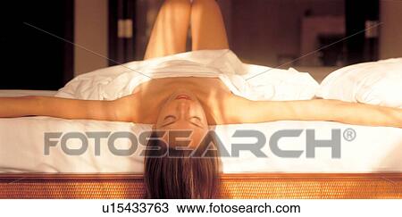 Stock Image - lying down, quarter length, culture, treatment, arms outstretched. Fotosearch