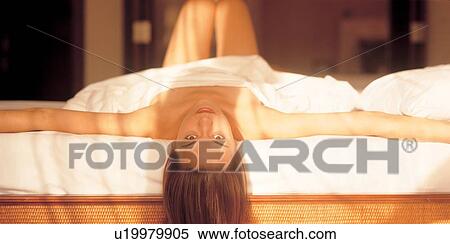 Stock Photography - semi dressed, looking at camera, bed, relaxing, idyllic, silence, young adult. Fotosearch