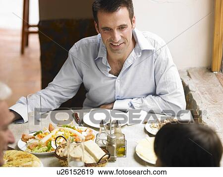 Stock Photo - Boy (8-10) sitting at café table with father and grandfather (differential focus). Fotosearch