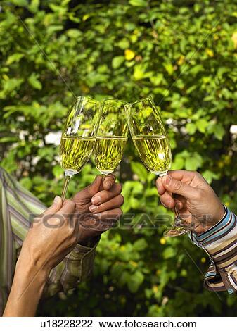 Stock Image - Close up of Champagne glasses touching. Fotosearch