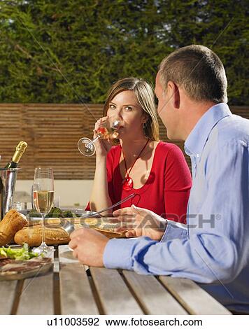 Stock Image - Couple eating meal outdoors. Fotosearch