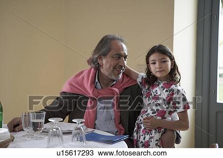 Girl (5-7) sitting with grandfather at a table View Large Photo Image Stock Image - Girl (5-7) sitting with grandfather at a table. Fotosearch