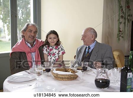 Girl (5-7) sitting with great-grandfather and grandfather at dinner table View Large Photo Image Stock Photography - Girl (5-7) sitting with great-grandfather and grandfather at dinner table. Fotosearch