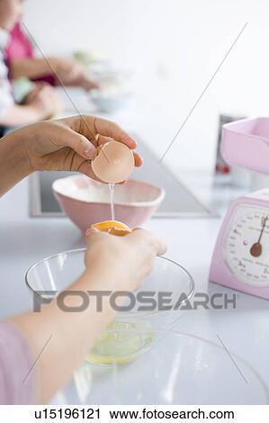 Girl separating egg yolk and egg white View Large Photo Image Stock Image - Girl separating egg yolk and egg white. Fotosearch