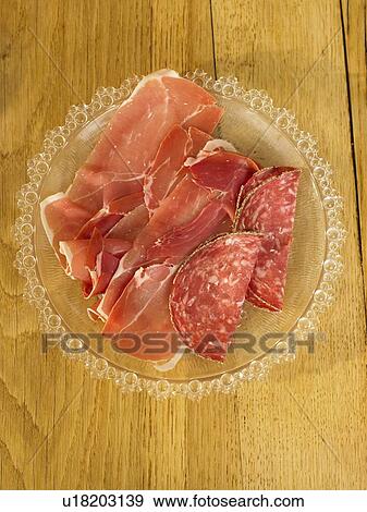 Stock Photo - Plate of salami and cured meat on table. Fotosearch