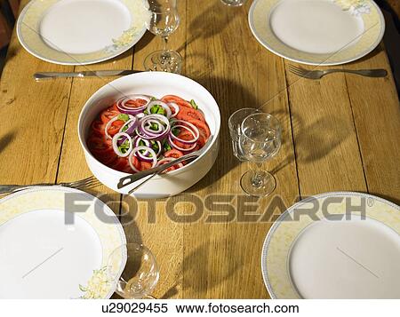 Stock Photography - Tomato and onion salad with four place settings on table. Fotosearch