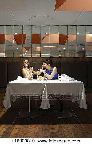Two women in a restaurant with a spoon on one's nose View Large Photo Image Stock Image - Two women in a restaurant with a spoon on one's nose. Fotosearch