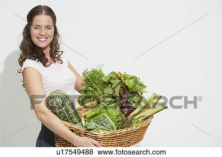 Young woman with large basket of organic vegetables. View Large Photo Image Stock Photo - Young woman with large basket of organic vegetables.. Fotosearch