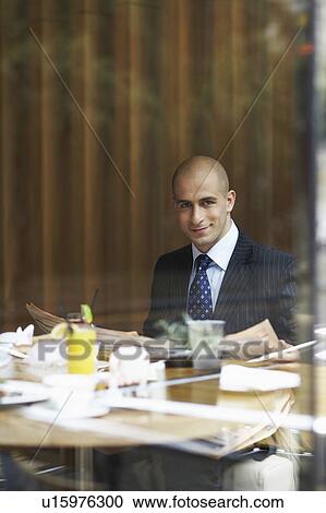 A businessman in a restaurant with a newspaper View Large Photo Image Stock Image - A businessman in a restaurant with a newspaper. Fotosearch