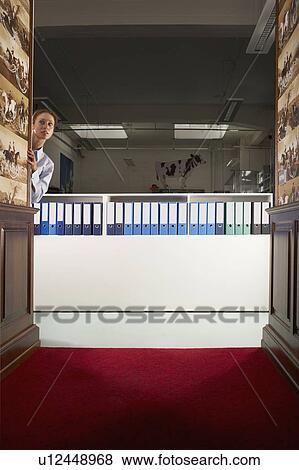 Stock Photo - Businesswoman in a hallway with binders . Fotosearch