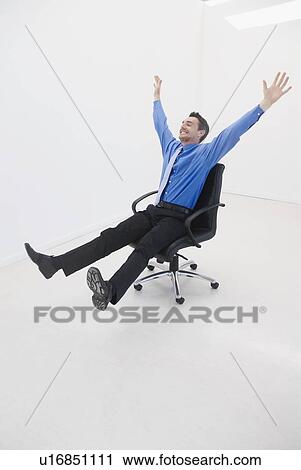 Man speeds through office on chair View Large Photo Image Stock Image - Man speeds through office on chair. Fotosearch