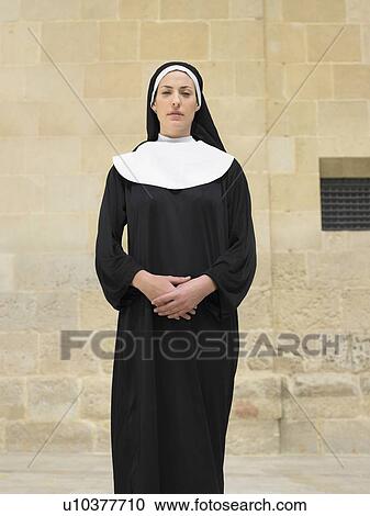 Stock Image - Portrait of nun clasping hands looking into camera, Alicante, Spain,. Fotosearch