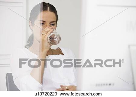 Woman at computer desk drinking water. View Large Photo Image Stock Photo - Woman at computer desk drinking water.. Fotosearch