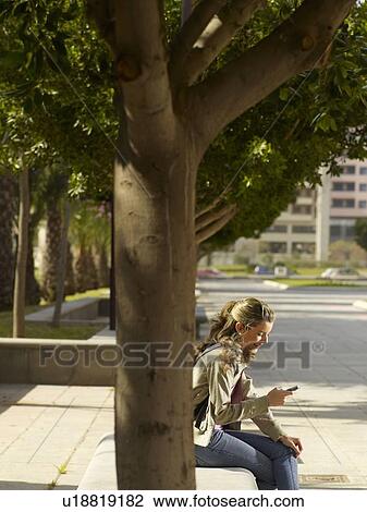 Stock Image - Teenage female on mobile phone. Fotosearch