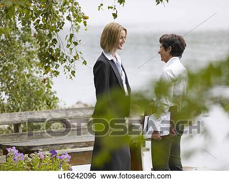Stock Photograph - Two businesswomen by lake. Fotosearch