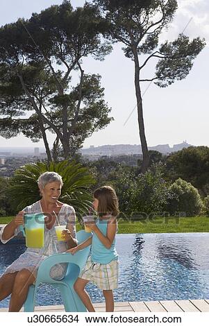 Older woman and young girl drinking juice. View Large Photo Image Picture - Older woman and young girl drinking juice.. Fotosearch